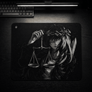 Uma visão aérea de uma mesa de madeira escura e texturizada, com um teclado mecânico preto visível no topo. No centro, está o Mouse Pad Control Gamer Justice V3, com uma ilustração detalhada em tons de cinza. A imagem no mouse pad mostra uma figura estilizada com longos cabelos escuros e uma coroa de espinhos, segurando uma balança de pratos em uma das mãos e uma espada por trás. A balança e a espada simbolizam a justiça e a força. Uma luz linear de LED está posicionada acima do teclado, iluminando a cena.