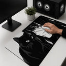 Vista superior de uma mesa branca com um monitor e um PC gamer de LED. No centro, é mostrado o Mouse Pad Grande Gamer Menina e Gato com detalhes em preto e branco com uma ilustração de estilo mangá de uma menina e um gato preto com olhos expressivos. Uma mão segura um mouse branco sobre o pad.