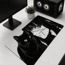 Visão superior angular do Mouse Pad Grande Gamer Menina e Gato estendido sobre uma mesa branca de configuração de PC. O mouse pad apresenta uma estampa detalhada em preto e branco de estilo mangá de um gato preto sentado com olhos expressivos e o rosto de uma menina com cabelos longos e cicatrizes faciais em forma de cruz. Um monitor e uma torre de PC gamer com ventoinhas de LED estão visíveis no fundo.