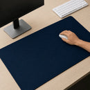 Mão de uma pessoa utilizando um mouse branco sobre o Mouse Pad Grande Gamer Ondas Azuis em uma mesa de madeira clara, compondo um setup com teclado e monitor.