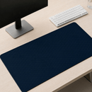 Visão em perspectiva diagonal do Mouse Pad Grande Gamer Ondas Azuis sobre uma mesa, posicionado em frente à base de um monitor e próximo a um teclado branco.
