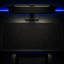 Vista superior do Mouse Pad Grande Gamer Ondas Escuras posicionado de forma centralizada em uma mesa. Acima dele, há um monitor com lightbar acesa e iluminação traseira em LED azul, destacando o espaço amplo e a estampa sutil do mouse pad.