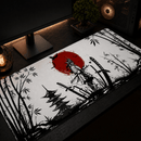 Vista isométrica de um mouse pad grande gamer samurai sobre uma mesa de madeira escura com um setup gamer. O mousepad exibe uma arte no estilo sumi-ê em preto e branco com detalhes em vermelho: no centro, a silhueta de um samurai de costas com uma espada embainhada e um grande sol vermelho ao fundo; à esquerda, um pagode de cinco andares e bambus; à direita, bambus e katanas cravadas no chão. O ambiente ao redor inclui um monitor preto de tela plana em um suporte, um computador e uma lâmpada edison.