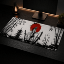 Um mousepad de tamanho grande repousa sobre uma mesa de madeira preta, apresentando um design no estilo sumi-ê. A arte central retrata um samurai de costas voltado para um grande sol vermelho, ladeado por bambus e um pagode japonês. Duas katanas, uma desembainhada e outra na bainha, ladeiam o guerreiro.
O mousepad é emoldurado por uma borda fina, e suas dimensões extra-longas acomodam confortavelmente um teclado e um mouse. Na parte traseira da mesa, um monitor e uma luminária de estilo industrial.