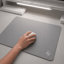 Mouse Pad Speed Gamer Galaxy Gem com textura híbrida balance cor cinza e logo branca no canto inferior direito do produto. Uma mão utiliza um mouse branco sobre o pad em um setup clean e iluminado.