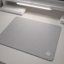 Mouse Pad Speed Gamer Galaxy Gem com base antiderrapante em mesa de escritório branca, com teclado mecânico branco e barra de luz LED visíveis em setup minimalista.