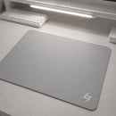 Mouse Pad Speed Gamer Galaxy Gem com base antiderrapante em mesa de escritório branca, com teclado mecânico branco e barra de luz LED visíveis em setup minimalista.