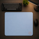 Visão superior do Mouse Pad Speed Ultradash Blue em um setup gamer organizado. O pad retangular azul domina o centro da mesa, com um mouse posicionado fora dele e um teclado na parte superior, ressaltando o amplo tamanho de 450x400mm para movimentos.